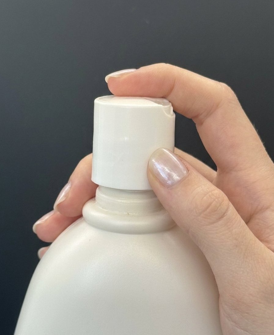 Swapping the replacement top onto a lotion bottle